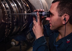 Aircraft powertrain repairer conducts inspection on Apache helicopter