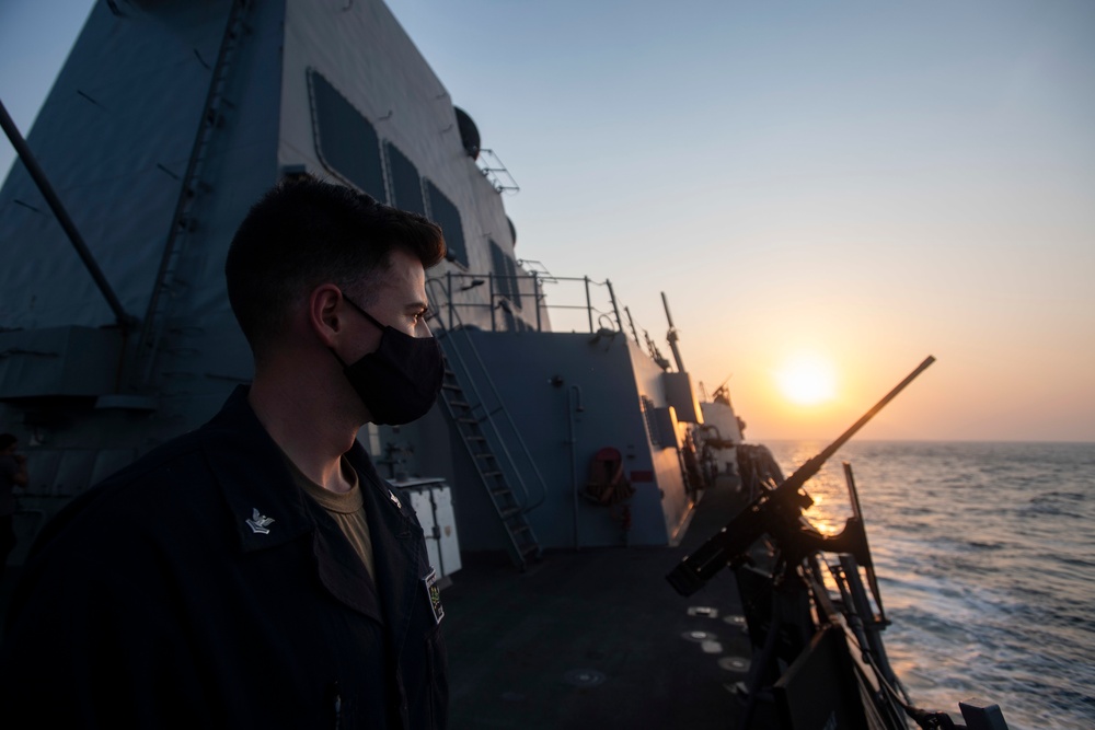 USS Ralph Johnson Sailors monitors for contacts at sunset