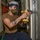 Aviation Support Equipment Technician Drills Hole For Lock Assembly Aboard Aircraft Carrier USS Nimitz CVN 68
