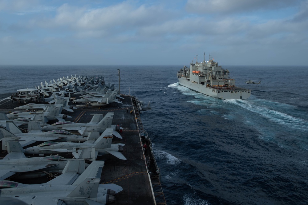 The aircraft carrier USS Nimitz (CVN 68) pulls alongside the Lewis and Clark-class dry cargo ship.