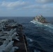 The aircraft carrier USS Nimitz (CVN 68) pulls alongside the Lewis and Clark-class dry cargo ship.