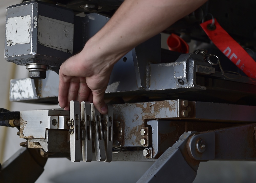 Weapons Airmen remove pylon for routine inspection