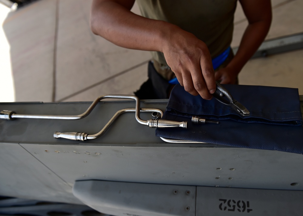 Weapons Airmen remove pylon for routine inspection