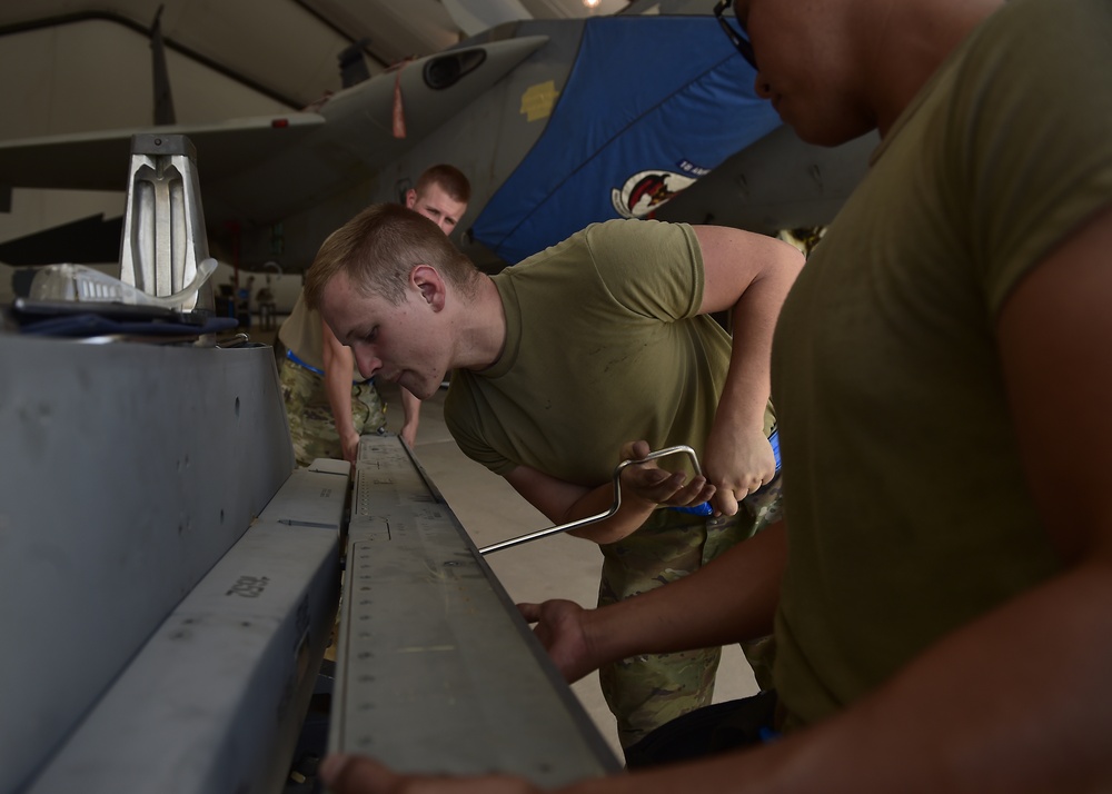 Weapons Airmen remove pylon for routine inspection