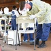 Sailor sanitizes chair in COVID-19 testing site between patients