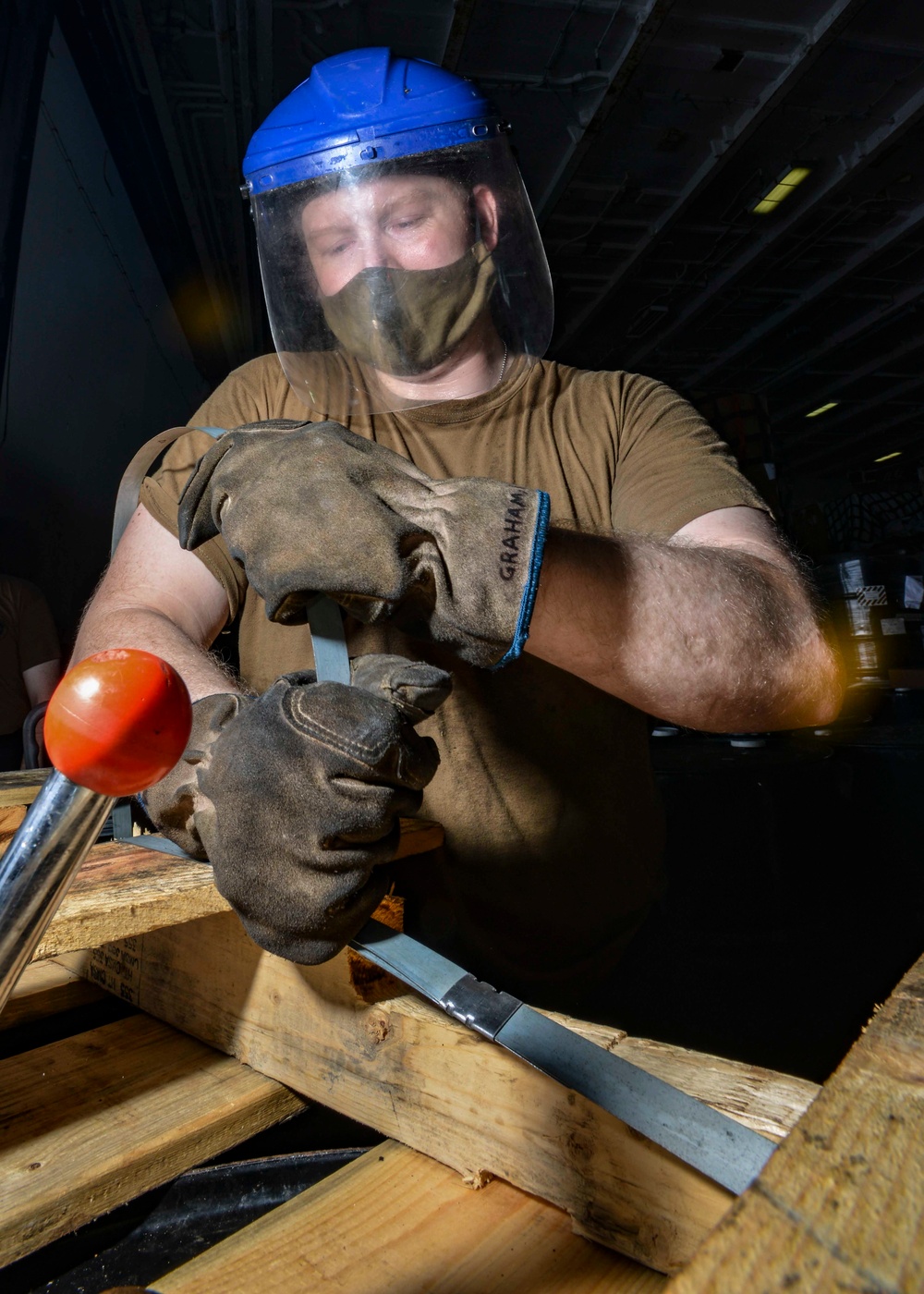 Logistics Specialist Binds Hydraulic Drums In Hangar Bay Aboard Aircraft Carrier CVN 68