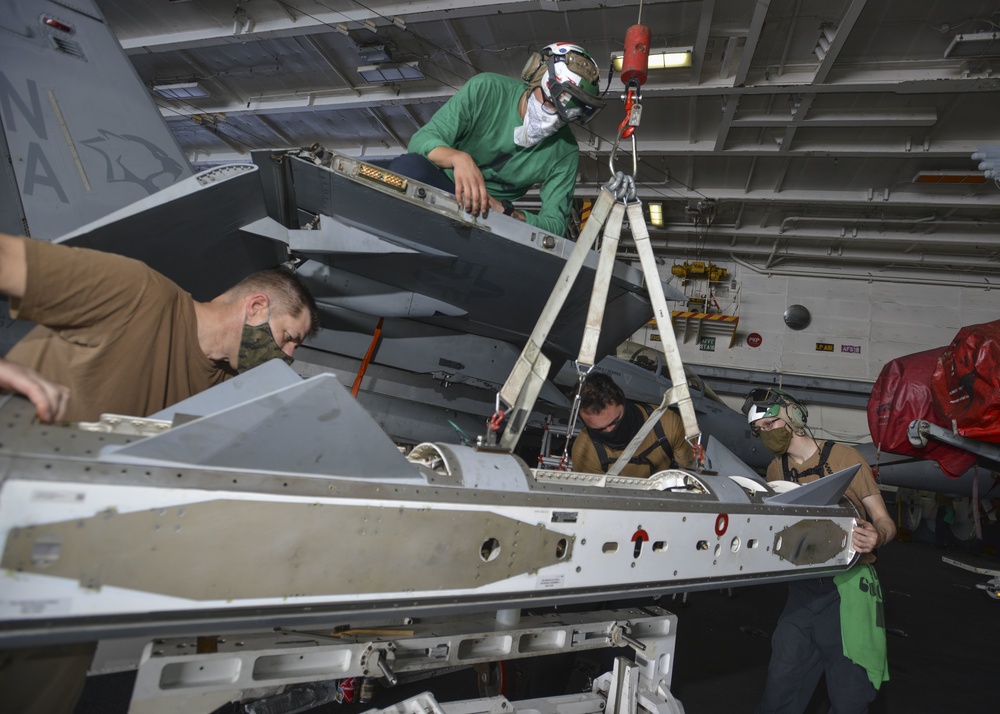 Sailors Raise E/A-18G Growler Wing Tip Pod In Hangar Bay Aboard Aircraft Carrier USS Nimitz CVN 68