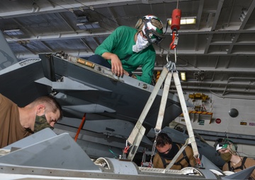 Sailors Raise E/A-18G Growler Wing Tip Pod In Hangar Bay Aboard Aircraft Carrier USS Nimitz CVN 68