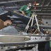 Sailors Raise E/A-18G Growler Wing Tip Pod In Hangar Bay Aboard Aircraft Carrier USS Nimitz CVN 68