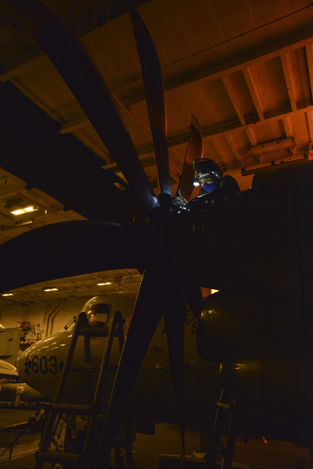 Aviation Machinist's Mate Installs Brush Block Assembly On Carrier Airborne Early Warning Squadron VAW 116 Sun Kings E-2C Hawkeye In Hangar Bay Aboard Aircraft Carrier USS Nimitz CVN 68