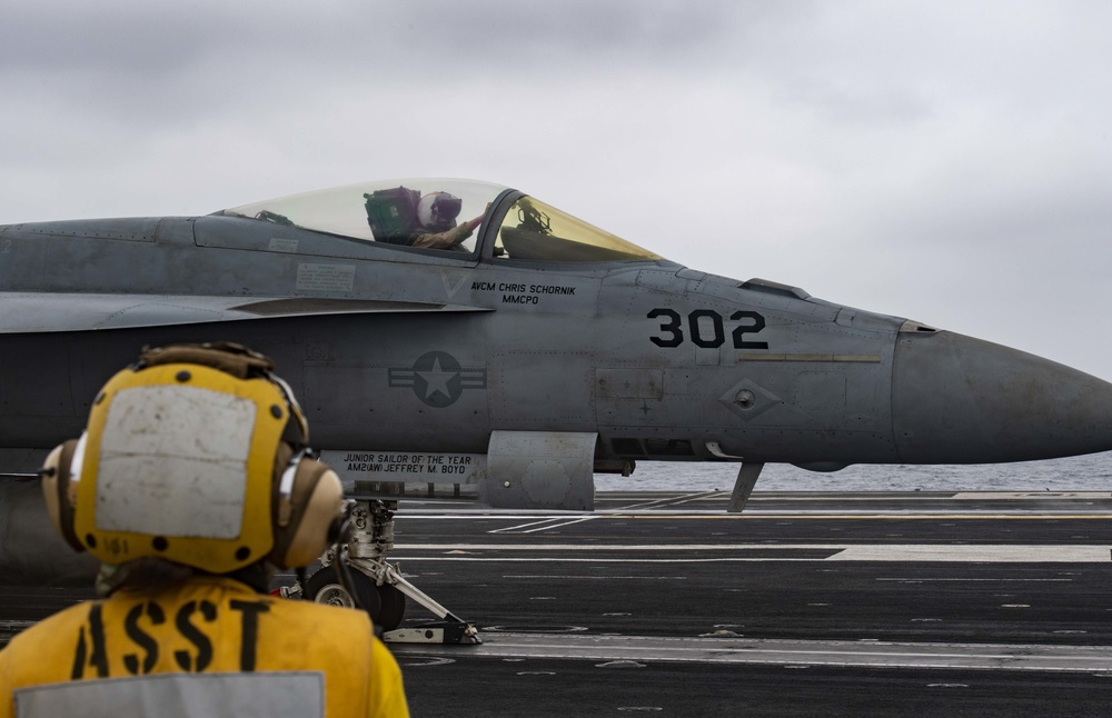 A Sailor Observes An F/A-18C Super Hornet Prepare To Launch Off Of The Flight Deck Aboard Nimitz