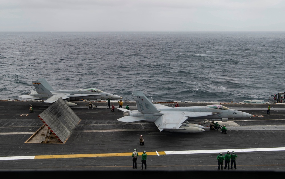 An F/A-18C Hornet and F/A-18E Super Hornetprepare to launch off the flight deck of the aircraft carrier USS Nimitz (CVN 68).