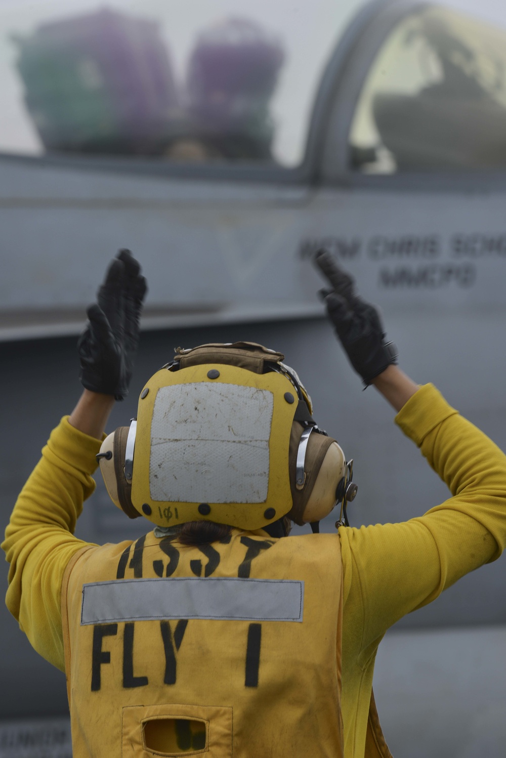 Aviation Boatswain's Mate (Handling) Signals To Pilot On Flight Deck Aboard Aircraft Carrier USS Nimitz CVN 68