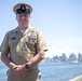 Senior Chief Cryptologic Technician (Collection) Jamey Stewart poses for a photo in front of the San Diego skyline