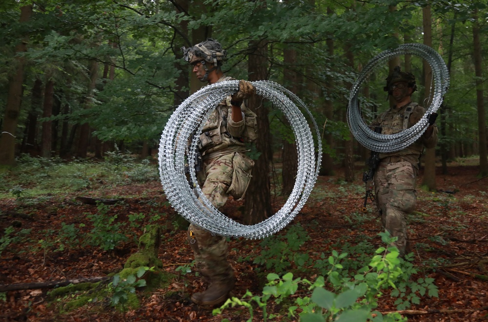 Laying concertina wire barriers