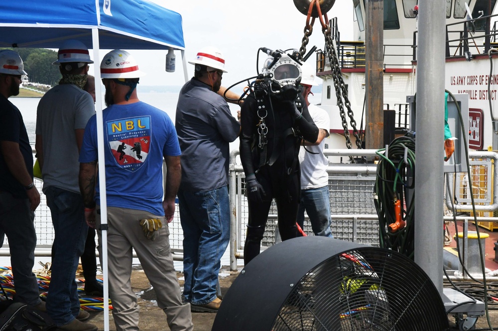 A USACE Diver is assisted with his equipment after completing his dive