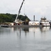 A USACE barge transport an 18 tone debris screen to shore after lifting from the water at Wilson Lock in Florence Ala.