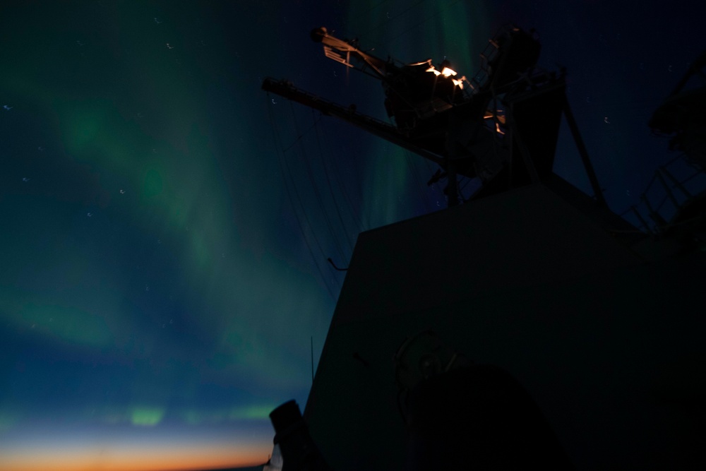 The Aurora Borealis Appears over the Arleigh Burke-class Guided-Missile Destroyer USS Thomas Hudner (DDG 116), During Operation Nanook-Tuugaalik