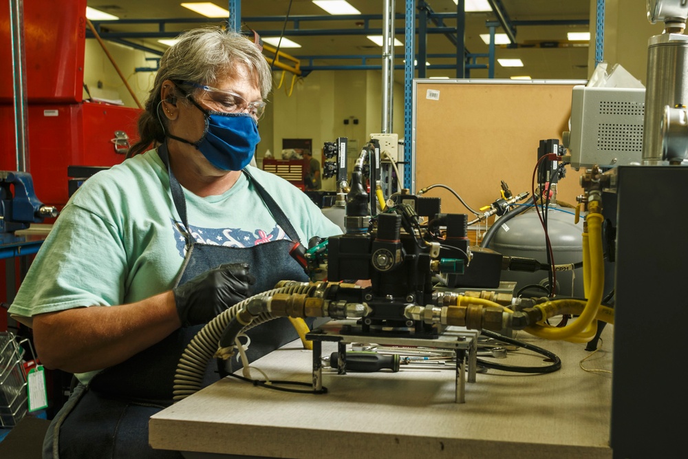 Martha Hunter connects a hydraulic component to a testing apparatus for a Stryker vehicle