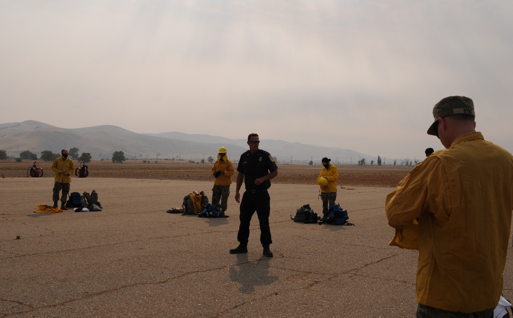 California Army National Guard Soldiers receive training from Cal Fire officers on the proper wear and use of their personal protective equipment