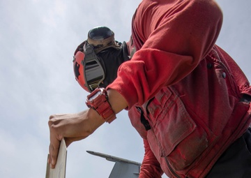 Aviation Ordnanceman Inspects Missile Wings And Fins On Flight Deck Aboard Aircraft Carrier USS Nimitz CVN 68