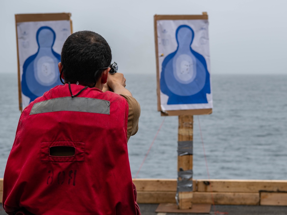 A Sailor participates in a small arms live fire exercise aboard the aircraft carrier USS Nimitz