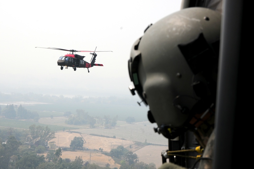 Cal Guard Soldiers work with CalFire firefighters to battle the LNU Lightning Complex fire