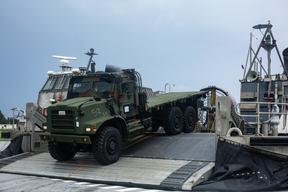Landing craft, air cushion hovercrafts on load 31st MEU trucks and heavy equipment