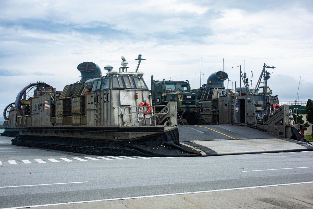 Landing craft, air cushion hovercrafts on load 31st MEU trucks and heavy equipment