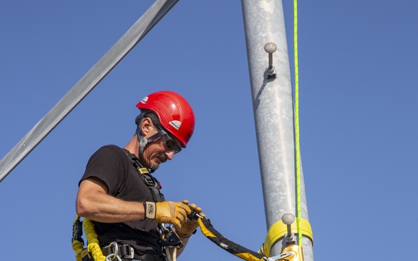 Electronic maintenance teams practice tower climbing to keep base communications flowing