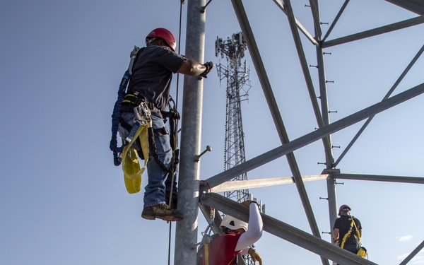 Electronic maintenance teams practice tower climbing to keep base communications flowing
