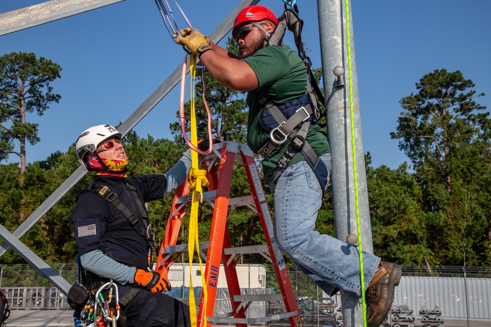 Electronic maintenance teams practice tower climbing to keep base communications flowing