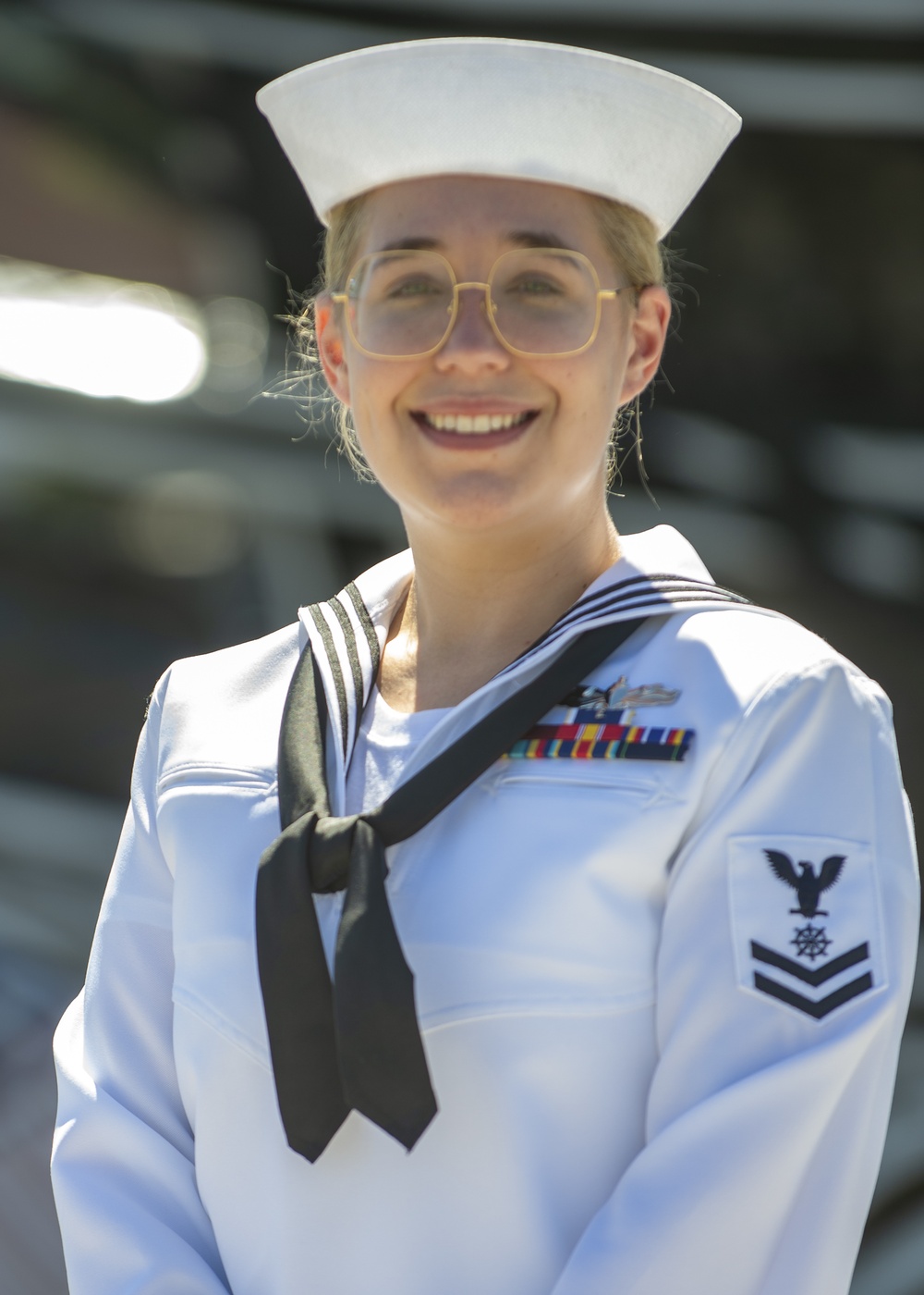 Quartermaster 2nd Class Rachel Dill poses for a photo in front of USS Constitution