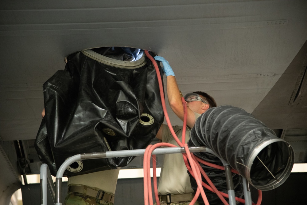 Multi-unit fuel system specialists team changes C-130 auxiliary fuel cell