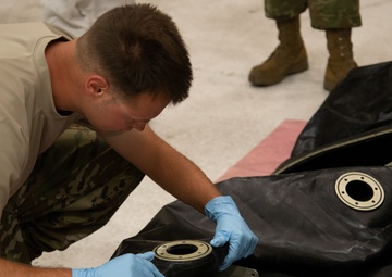 Multi-unit fuel system specialists team changes C-130 auxiliary fuel cell