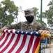 U.S. Army Spc. Wilsam Alicea rolls the American flag for storage