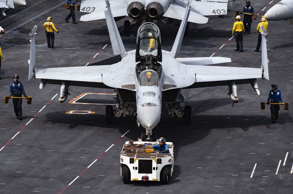 Sailors Taxi An F/A-18E Super Hornet Across The Flight Deck Aboard Nimitz