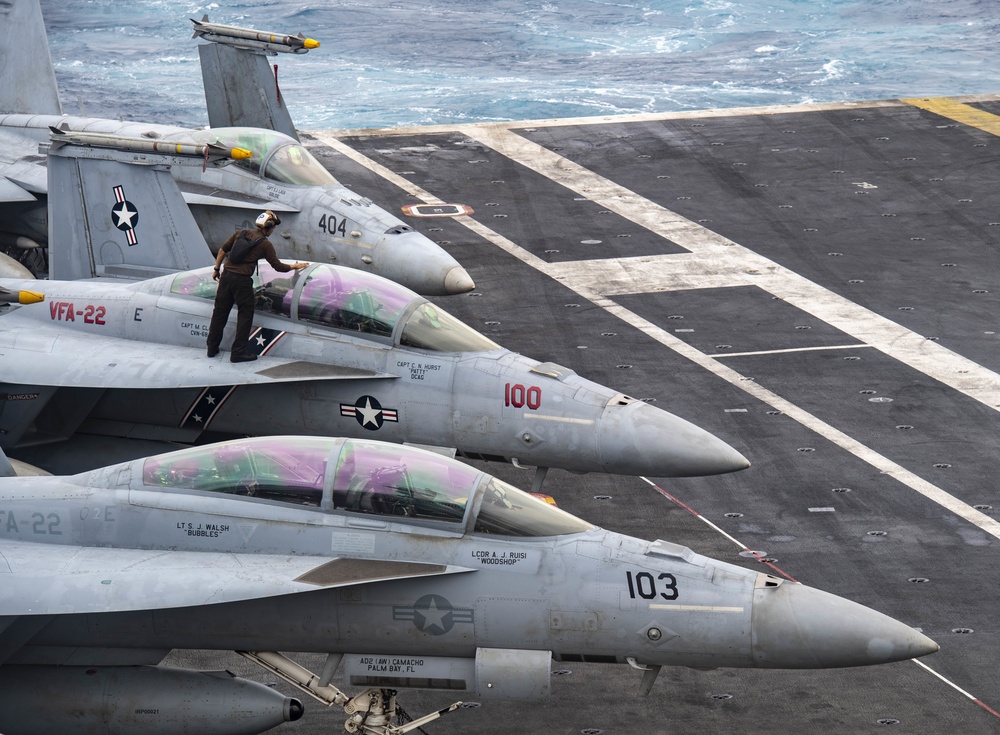 A Sailor Cleans The Cockpit Of An F/A-18F Super Hornet On The Flight Deck Aboard Nimitz