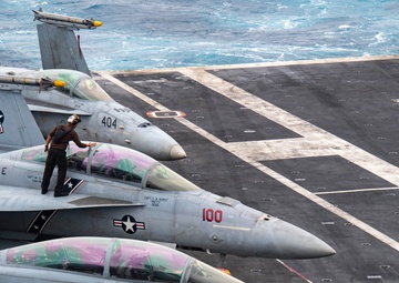 A Sailor Cleans The Cockpit Of An F/A-18F Super Hornet On The Flight Deck Aboard Nimitz
