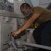 Sailor Tightens Jack For Engine Container Movement