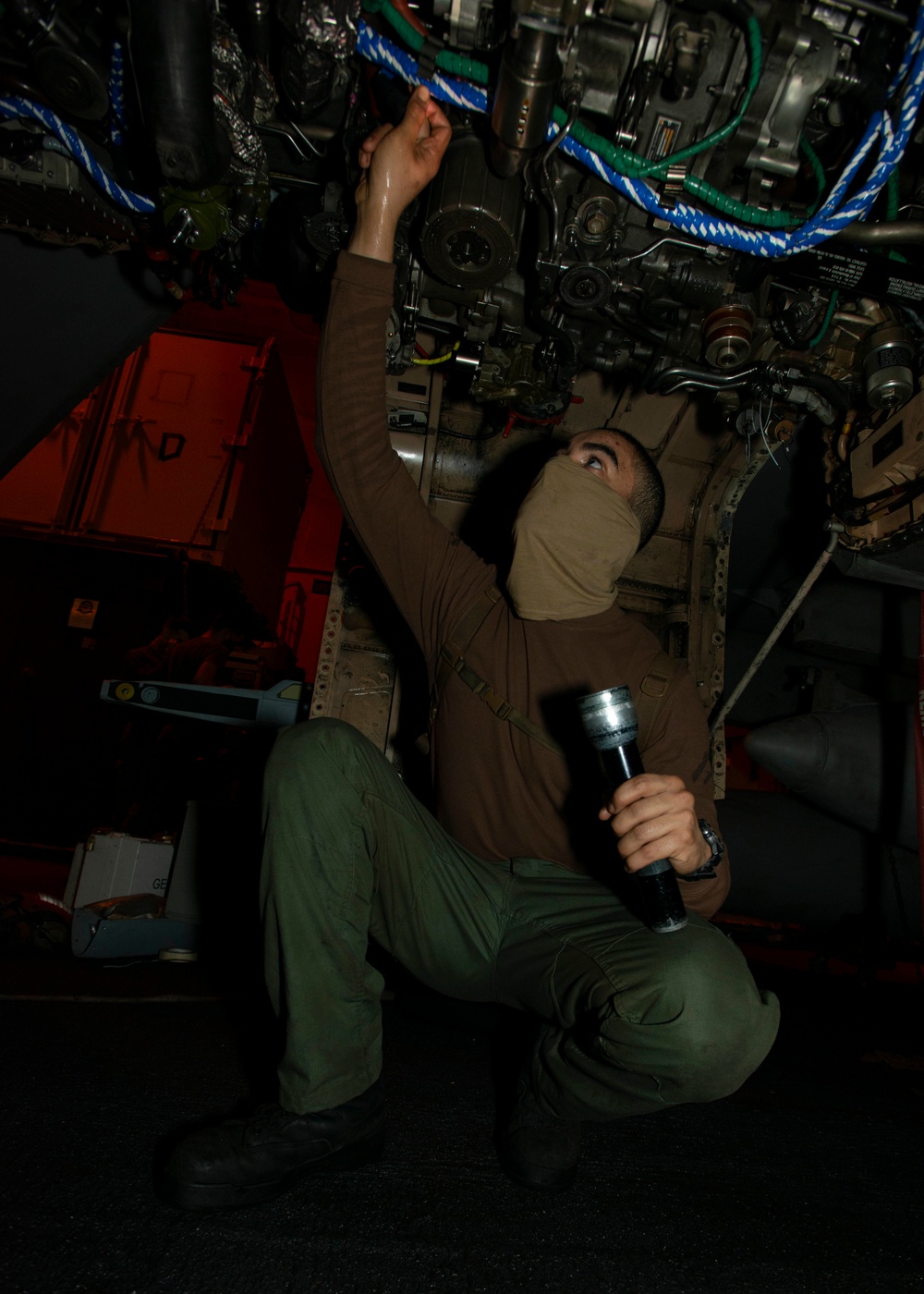 Lance Corporal Verifies Security Of Cable On E/A-18C Hornet, from the &quot;Death Rattlers&quot; of Marine Fighter Attack Squadron (VMFA) 323, In Hangar Bay Aboard Aircraft Carrier USS Nimitz CVN 68