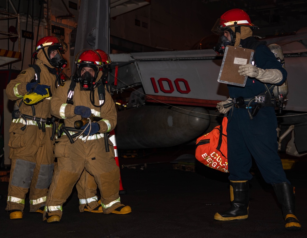 Sailors conduct firefighting training during a General Quarters drill in the hangar bay of the aircraft carrier USS Nimitz (CVN 68).