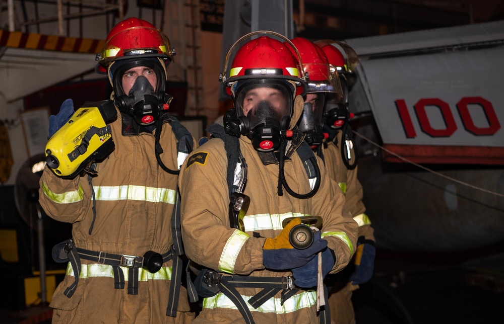 Sailors conduct firefighting training during a General Quarters drill in the hangar bay of the aircraft carrier USS Nimitz (CVN 68)
