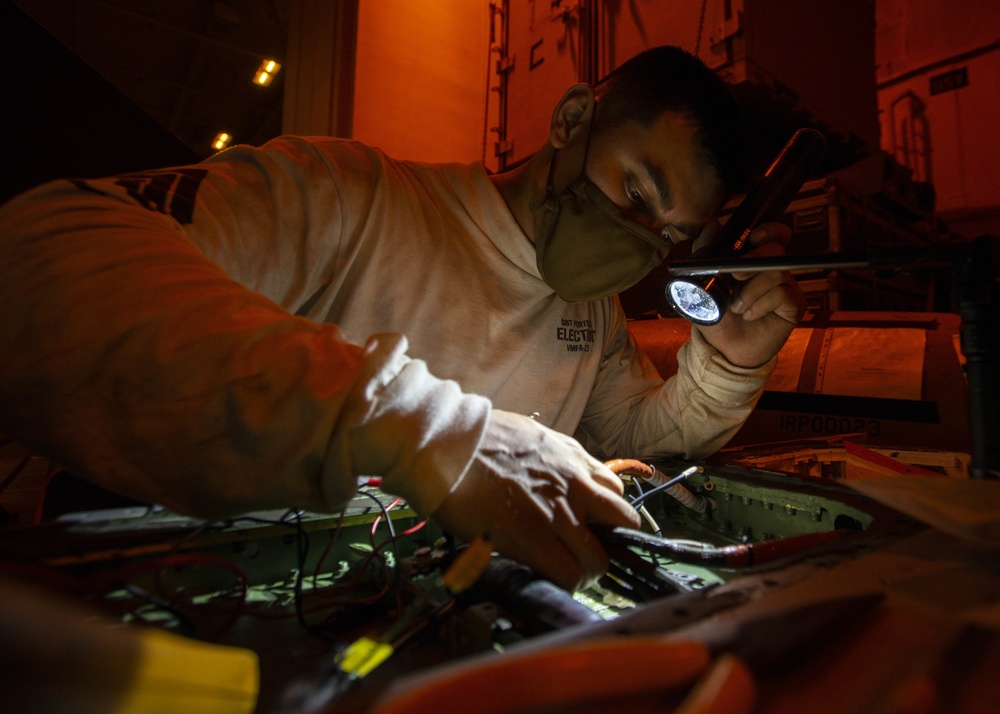 Marine Installs Outer Wing Harness On An F/A-18C Hornet, From &quot;Death Rattlers&quot; of Marine Fighter Attack Squadron (VMFA) 323, In Hangar Bay Aboard Aircraft Carrier USS Nimitz CVN 68
