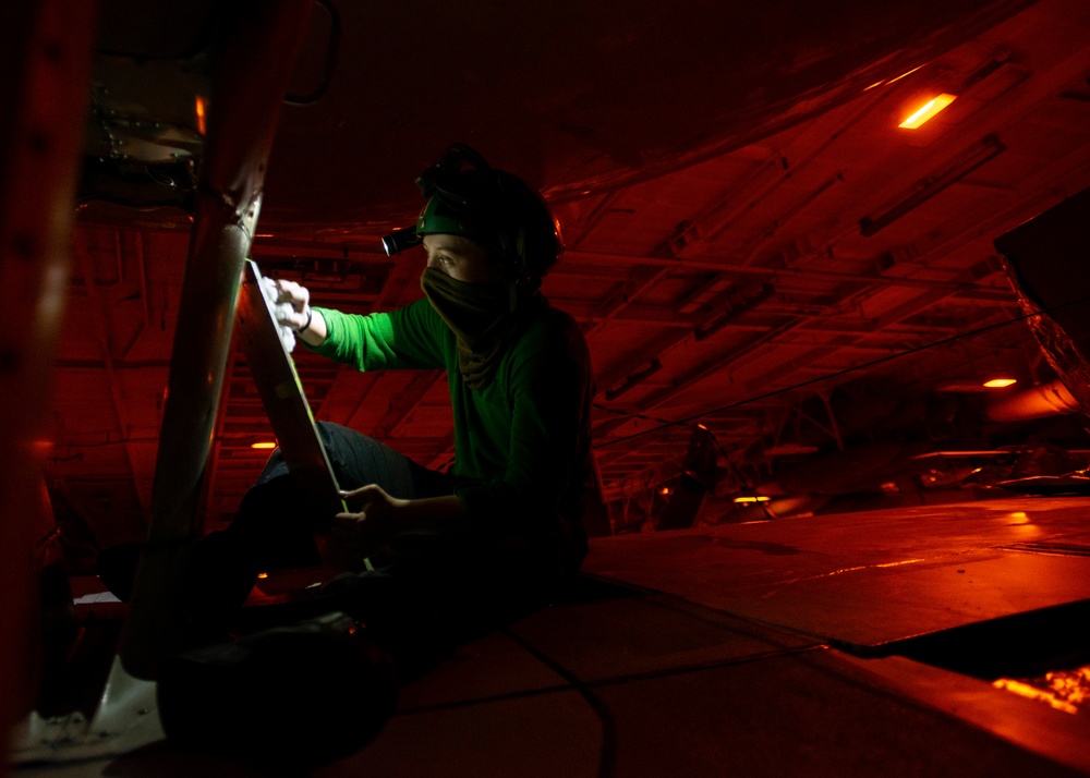 Aviation Structural Mechanic Performs Corrosion Prevention Maintenance On E-2C Hawkeye, From &quot;Sun Kings&quot; Of Carrier Airborne Early Warning Squadron (VAW) 116, In Hangar Bay Aboard Aircraft Carrier USS Nimitz CVN 68