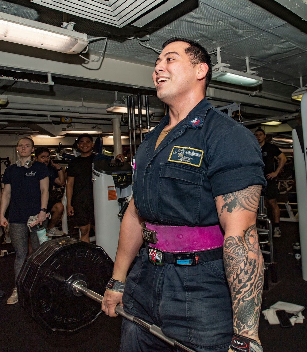 Machinist's Mate (Nuclear) 1st Class Pacifico Delafuente deadlifts during his re-enlistment ceremony aboard the aircraft carrier USS Nimitz (CVN 68).