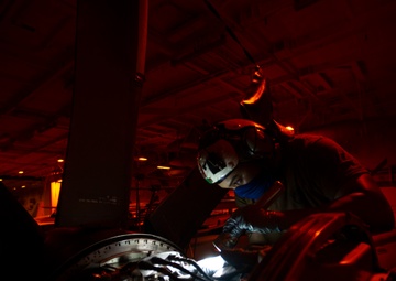 Aviation Machinist's Mate Inspects Brush Block Assembly On Carrier Airborne Early Warning Squadron VAW 116 Sun Kings E-2C Hawkeye In Hangar Bay Aboard Aircraft Carrier USS Nimitz CVN 68