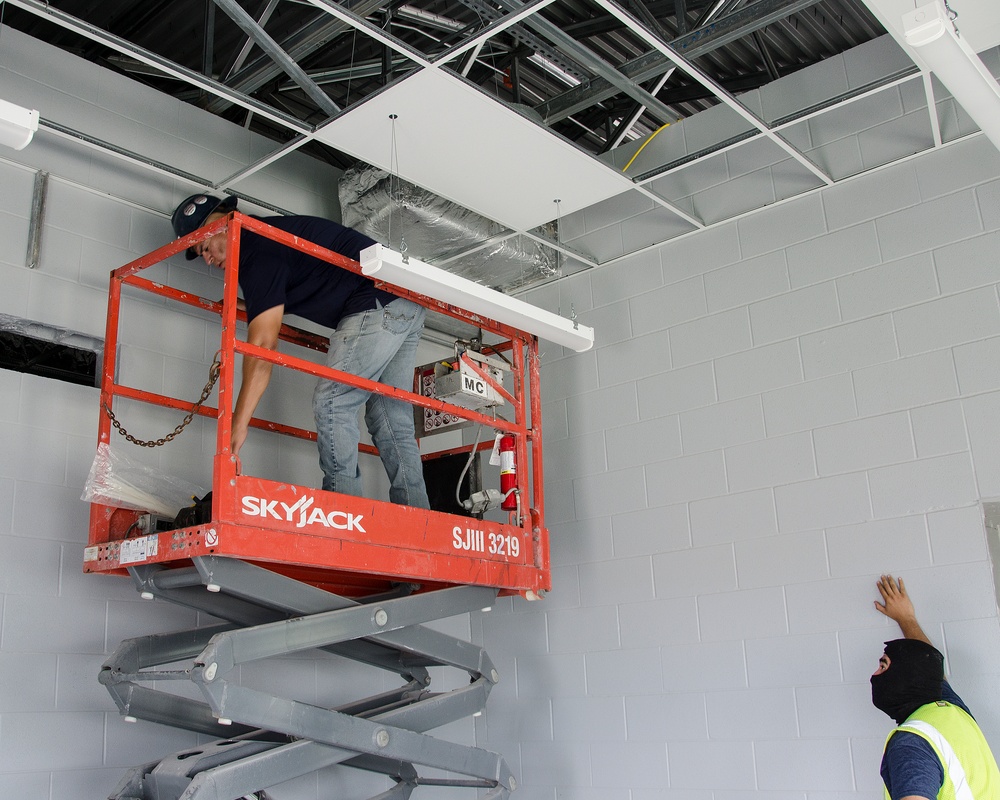 Workers wiring a runway lighting control vault