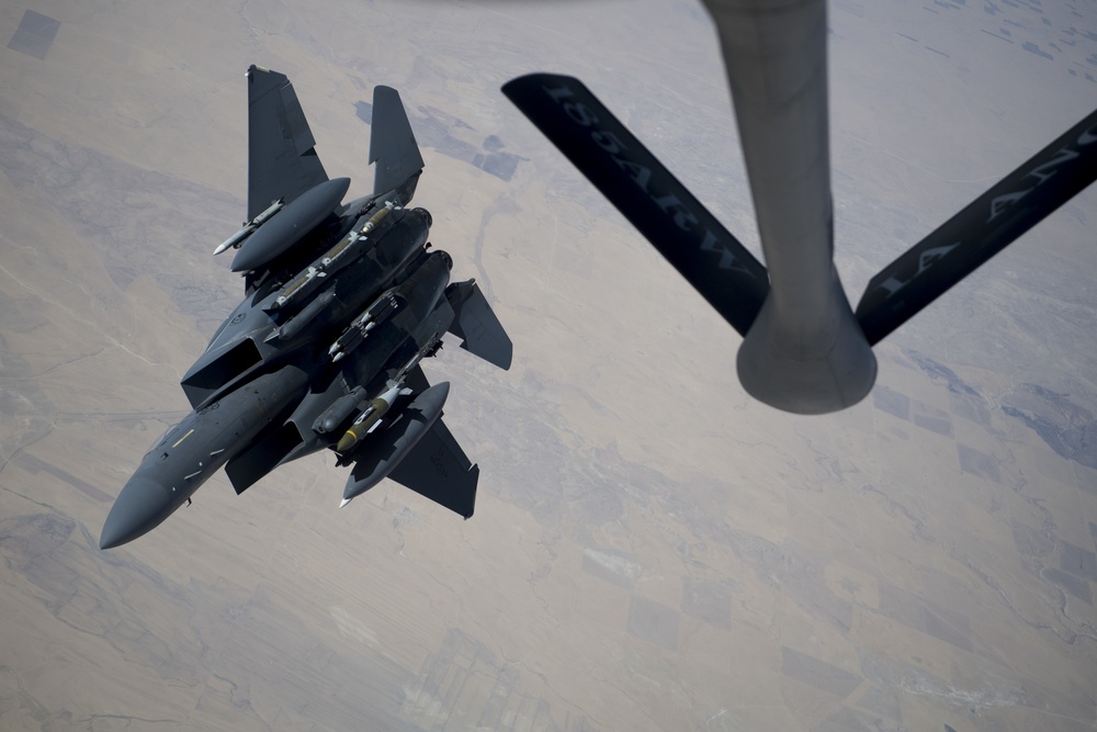 A U.S. Air Force KC-135 Stratotanker refuels F-15E Strike Eagles