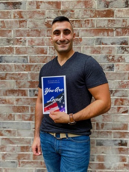 Air National Guard Senior Airman Nicholas Cammaroto poses with a copy of his debut book, “You Are Loved”